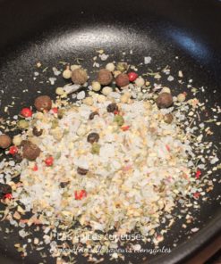 Mélange d'épices et de sel dans une poêle noire pour rehausser vos plats avec saveurs et arômes.