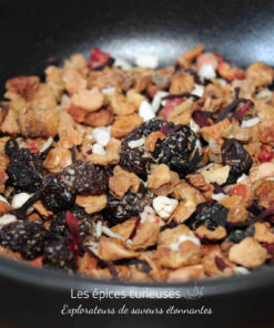 Mélange de fruits secs et baies dans un bol noir, prêt pour une infusion de tisane délicieuse et naturelle.