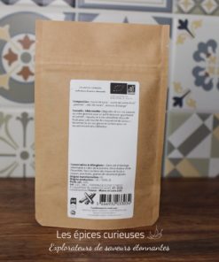 Paquet d'épices bio sur fond de carreaux colorés, idéal pour recettes créatives et gourmandes.