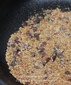 Gros sel et assaisonnements variés dans un bol noir prêts pour la cuisine.