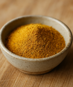 Bol de poudre de curry jaune sur planche en bois, épice exotique pour plats savoureux.