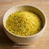 Bol de curry en poudre jaune avec des herbes, parfait pour rehausser vos plats avec une touche épicée et aromatique.