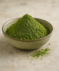 Bol de poudre de thé matcha vert vif sur une surface en pierre.