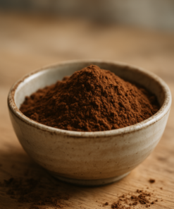 Bol en céramique avec de la poudre de cacao sur une table en bois.