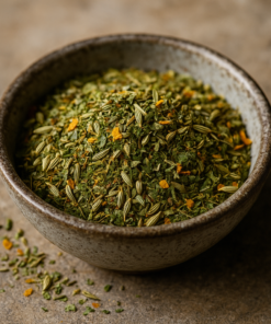 Bol de fines herbes séchées et épices colorées sur une table en pierre, idéal pour assaisonner les plats.