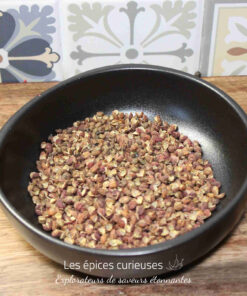 Bol de poivre de Sichuan sur fond de carreaux colorés dans une cuisine rustique.