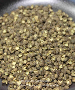 Grains de poivre vert dans une poêle, prêts à être utilisés pour rehausser vos recettes culinaires.