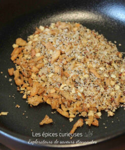 Assortiment de chapelure et d'épices dans une poêle noire pour un plat savoureux et croustillant.