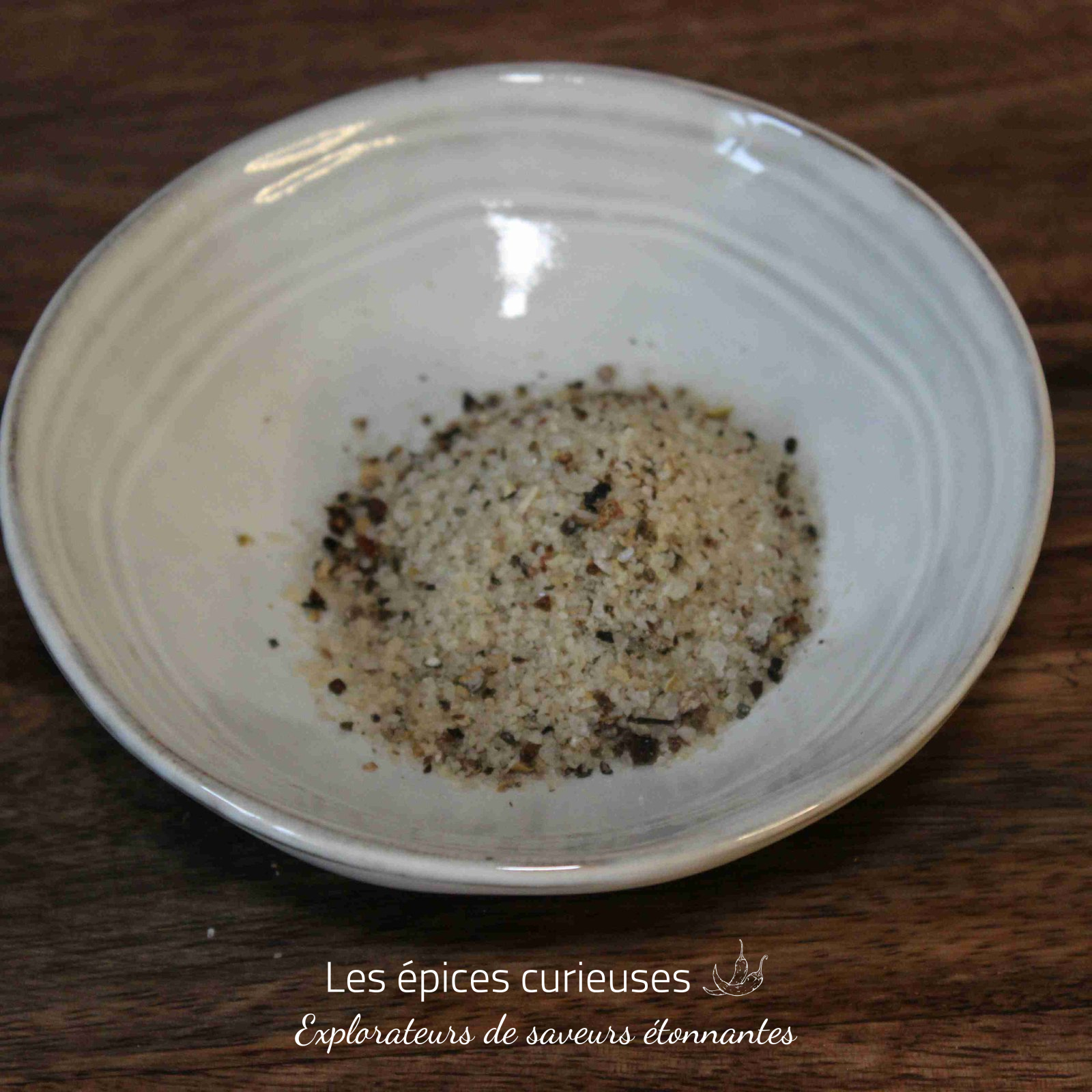 Fleur de sel aux poivres du monde (1)(1) Assiette de sel de mer assaisonné, posée sur une table en bois. Parfait pour rehausser vos plats culinaires.