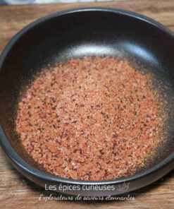 Bol de sel rose épicé sur une table en bois, prêt pour sublimer vos plats.