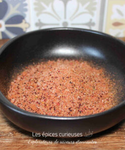 Sel rose de l'Himalaya dans un bol noir sur fond de carreaux décoratifs.