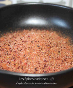Sel rose épicé dans un bol noir pour rehausser vos plats culinaires avec une touche exotique et savoureuse.