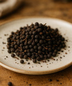 Assiette de clous de girofle séchés sur une table en bois, ingrédients pour la cuisine et les infusions épicées.