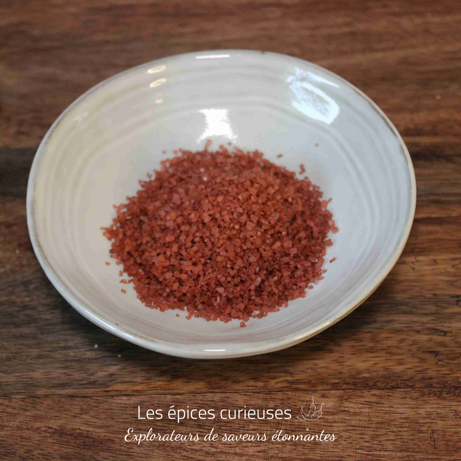 Sel rouge d’hawai (1)(1) Bol de sel de mer rouge sur une table en bois, idéal pour la cuisine épicée et les plats gourmets.