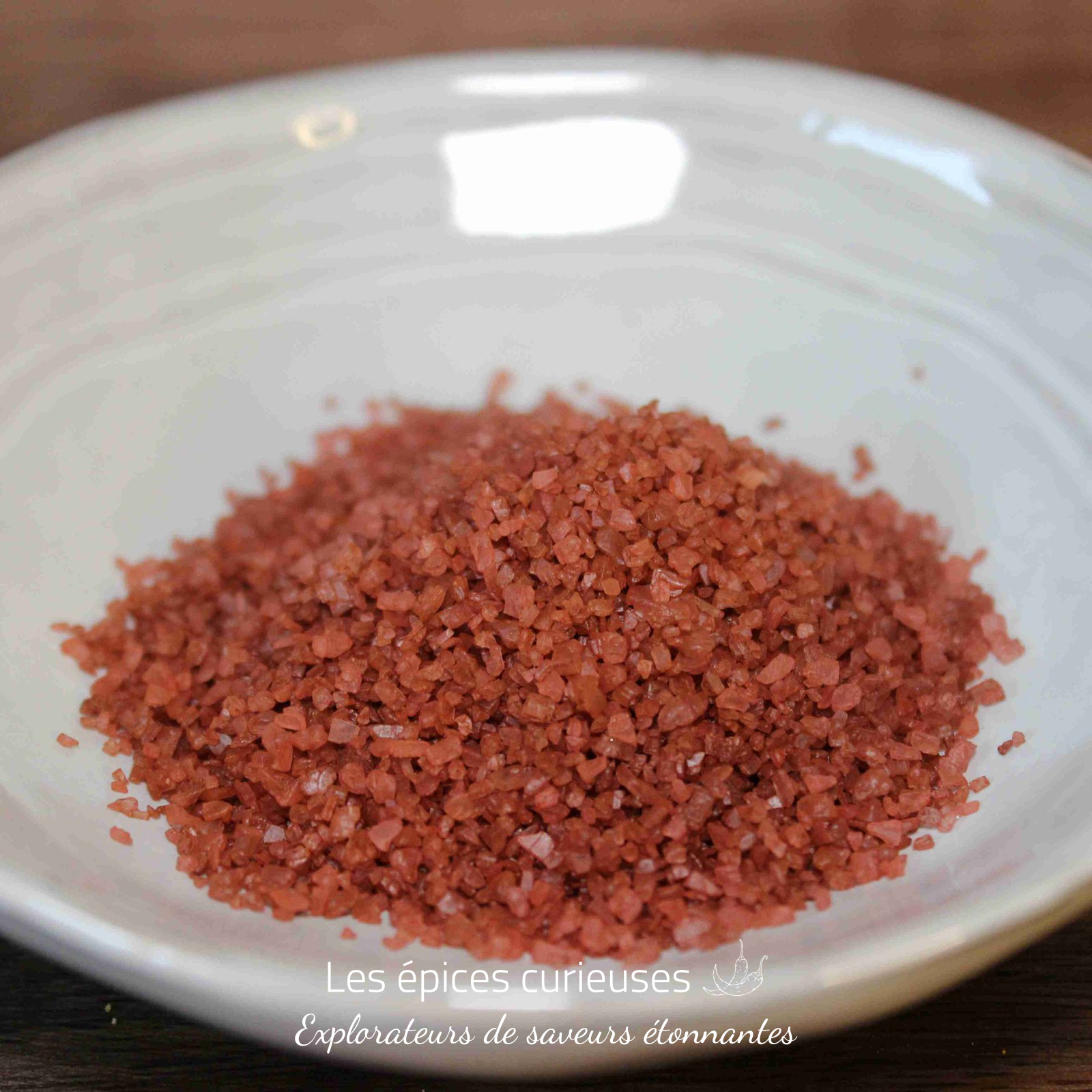Sel rouge d’hawai (5)(1) Sel rouge d'Hawaï dans un bol blanc sur une table en bois, prêt à sublimer vos plats avec une touche exotique.