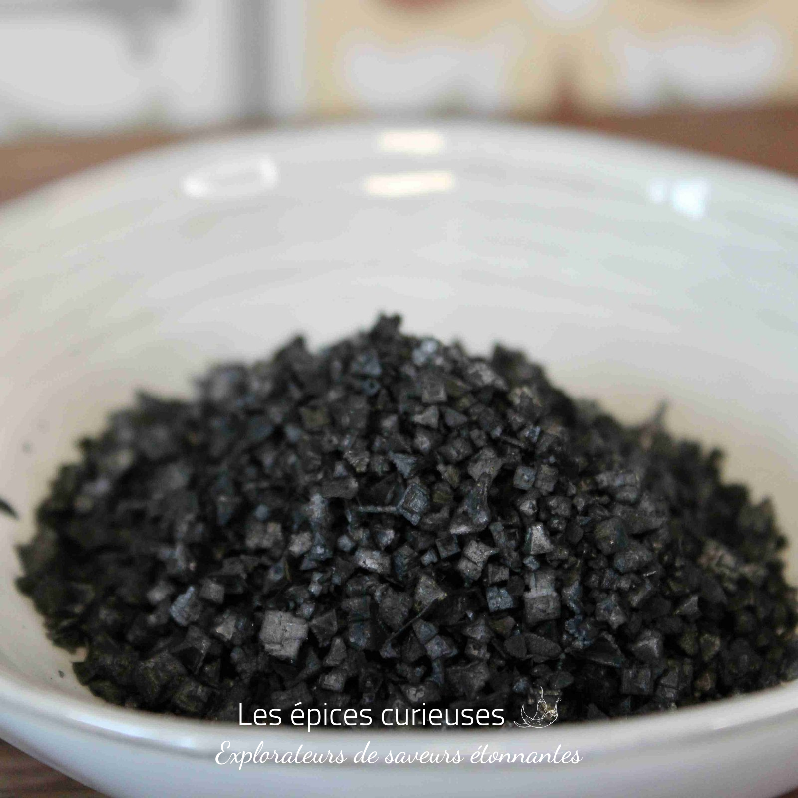 Fleur de sel Pyramide noir – Les épices curieuses Sel noir de mer dans un bol blanc, parfait pour rehausser vos plats avec une touche exotique et subtile.