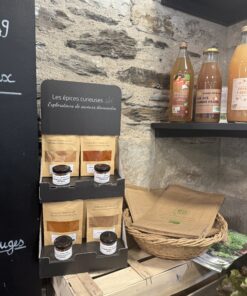 Épices et jus bio exposés sur étagères en pierre, mettant en valeur des saveurs uniques et naturelles dans une boutique.