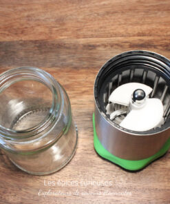 Bocal en verre et base de mixeur en acier inoxydable sur une table en bois, vue de dessus.