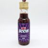Bouteille de sauce piquante Chilli Boom avec étiquette violette et bouchon doré, idéale pour rehausser vos plats.
