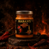 Pot de sauce piquante Anasthésie Haban's entouré de piments rouges sur fond de flammes ardentes.